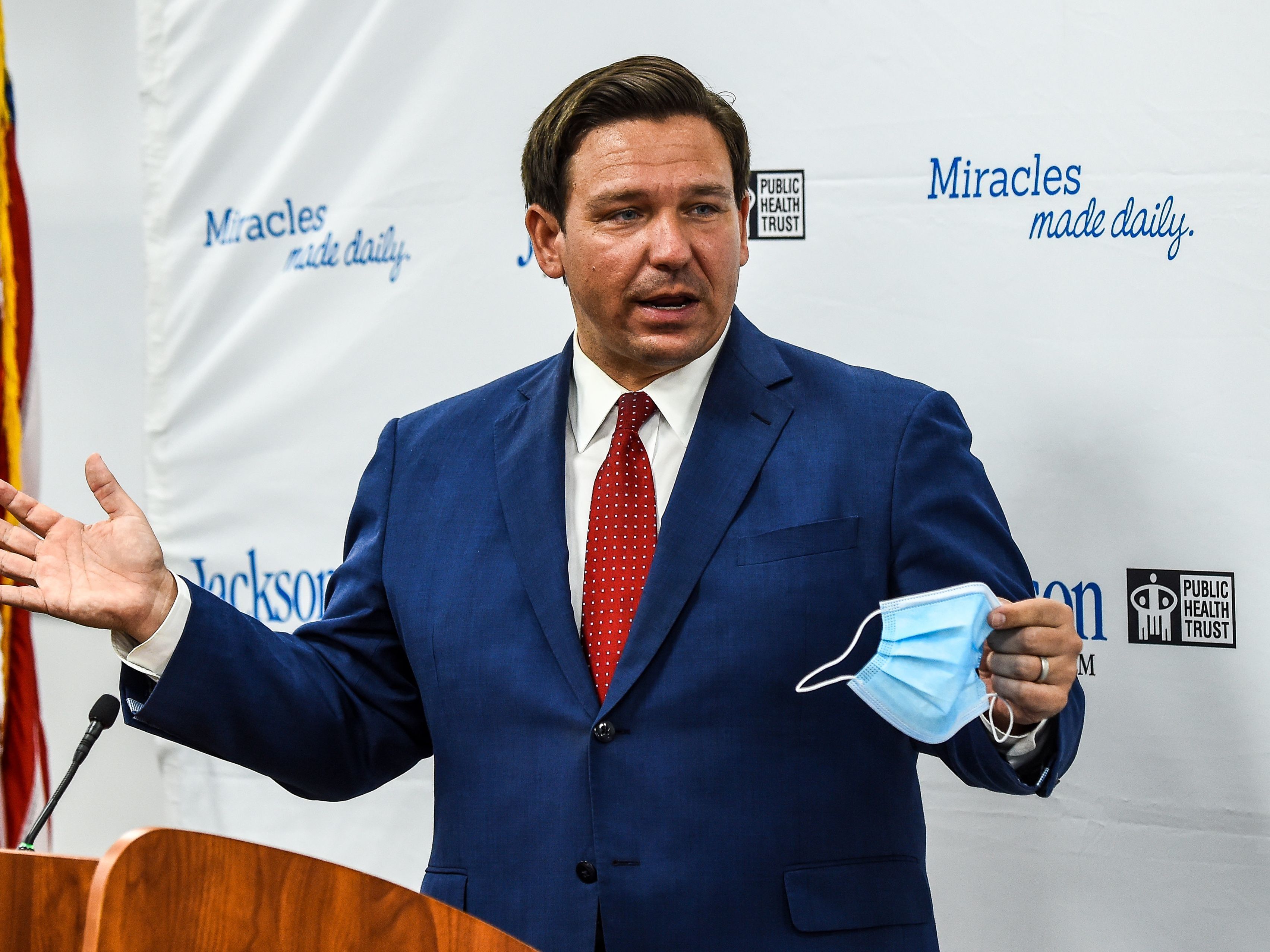 caption: Florida Gov. Ron DeSantis speaks holding his facemask during a press conference to address the rise of coronavirus cases in the state, at Jackson Memorial Hospital in Miami, on July 13, 2020.