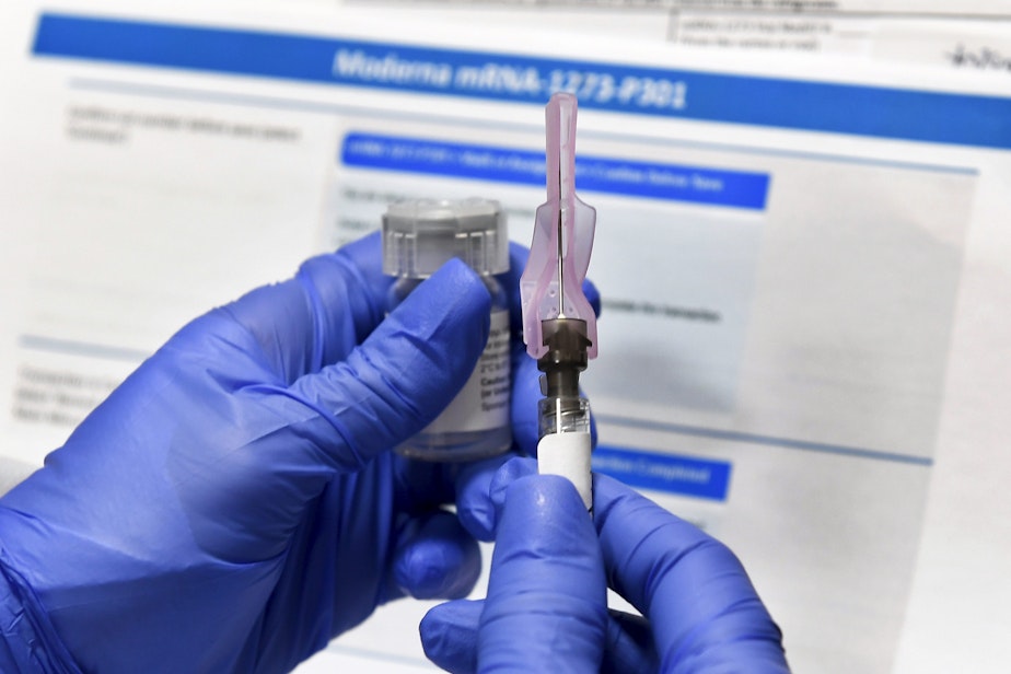 caption: In this July 27, 2020 file photo, a nurse prepares a shot as a study of a possible COVID-19 vaccine, developed by the National Institutes of Health and Moderna Inc., gets underway in Binghamton, N.Y. (Hans Pennink/AP)