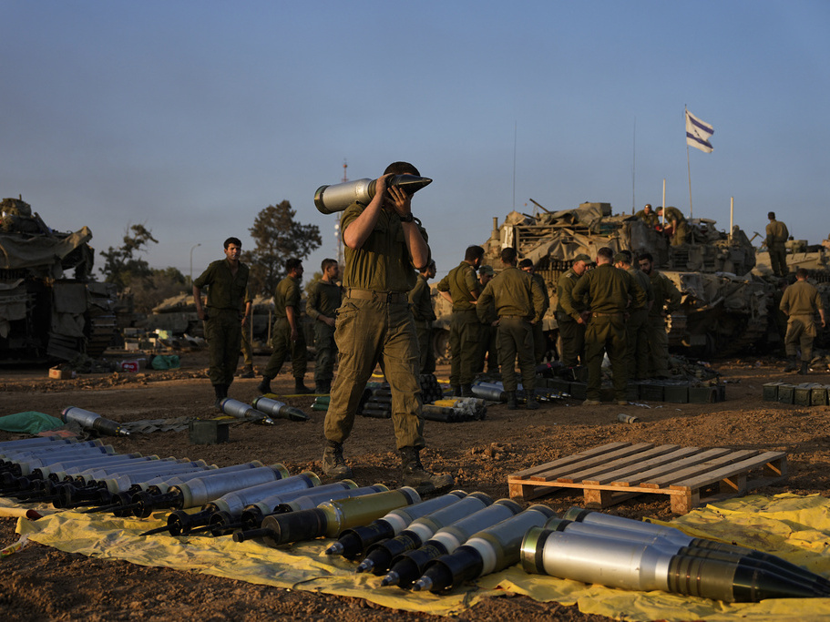 caption: Israeli soldiers load shells onto a tank Sunday at a staging area in southern Israel near the border with Gaza. The army is battling Palestinian militants across Gaza in the war ignited by Hamas' Oct. 7 attack into Israel.