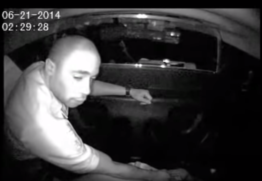 caption: In this screenshot from a Seattle Police Department video, Officer Adley Shepherd holds down a woman in the back of a squad car after the confrontation in which he punched her in the face while handcuffed.