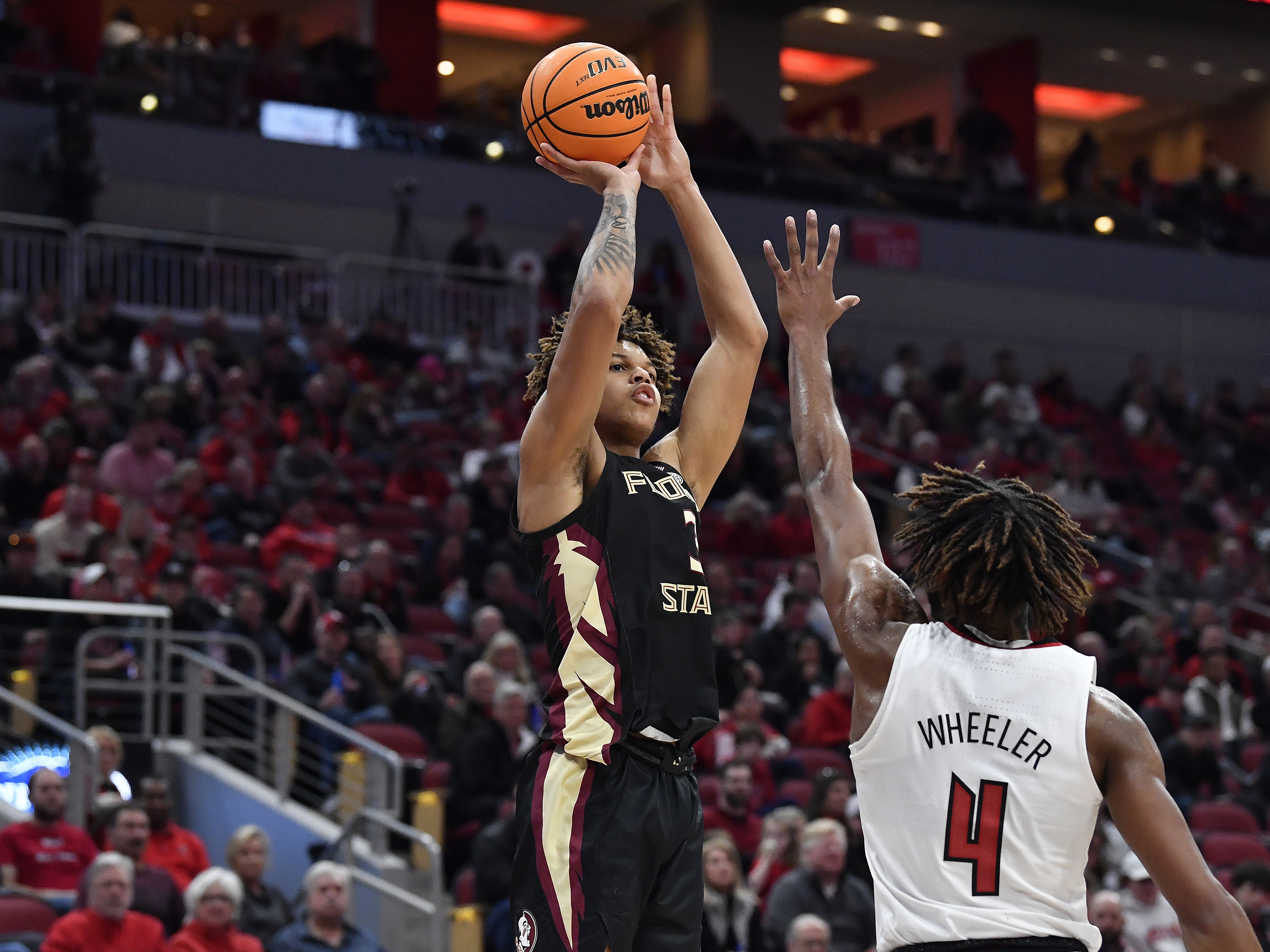 caption: Florida State forward Cam Corhen (L), shoots over Louisville forward Roosevelt Wheeler during an NCAA college basketball game in Louisville, Ky., Feb. 4, 2023. Corhen says he experienced online harassment when he played basketball at FSU.