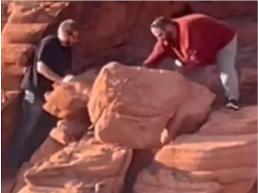 caption: An image provided by the National Park Service shows two men who were caught on video earlier this month toppling rock formations near the Redstone Dunes Trail.