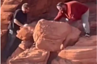 caption: An image provided by the National Park Service shows two men who were caught on video earlier this month toppling rock formations near the Redstone Dunes Trail.
