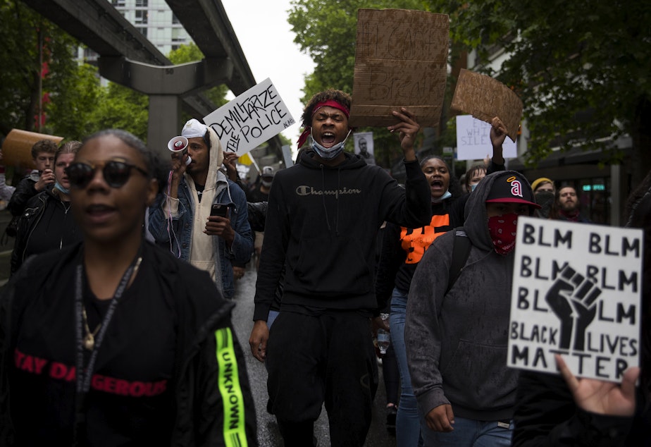 caption: Da'miracle Muse, center, leads a chant, -- 'we do this for our children. We do this for our children's children,' while marching in protest of the murder of George Floyd on Saturday, May 30, 2020, in Seattle.