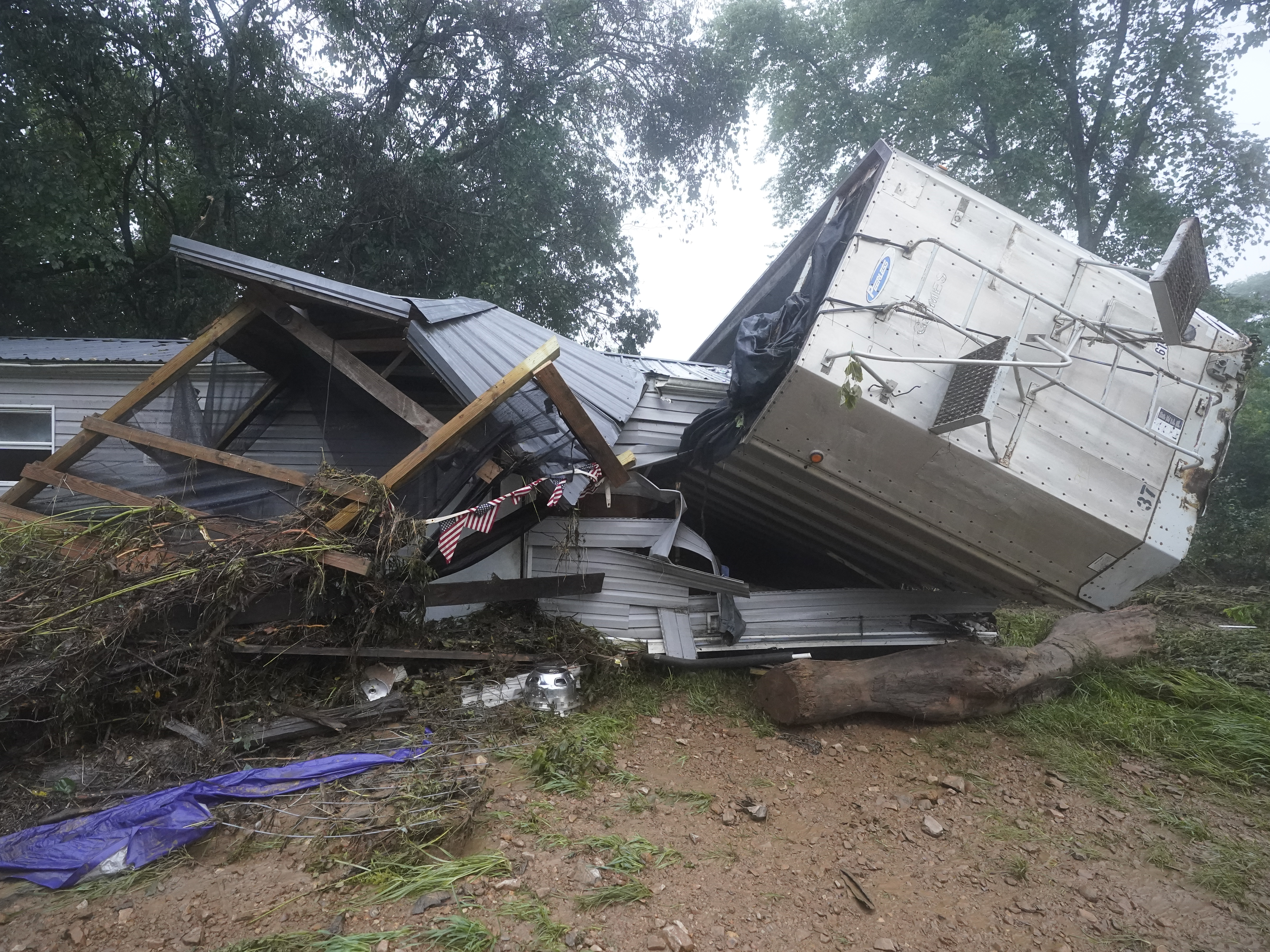 caption: A mobile home and a truck trailer sit near a creek Sunday after they were washed away by flood waters the day before in McEwen, Tenn. Heavy rains caused flooding in middle Tennessee and have resulted in multiple deaths as homes and rural roads were washed away.