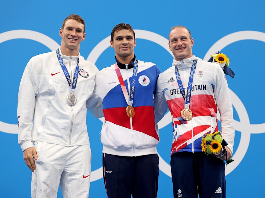 caption: Silver medalist Ryan Murphy of Team USA (from left), gold medalist Evgeny Rylov of the Russian Olympic Committee and bronze medalist Luke Greenbank of Great Britain during Friday's medal ceremony for the men's 200-meter backstroke final at the Tokyo Games.