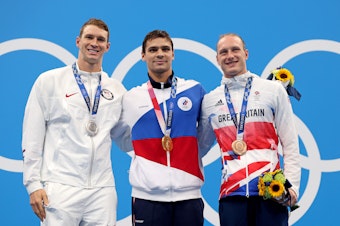 caption: Silver medalist Ryan Murphy of Team USA (from left), gold medalist Evgeny Rylov of the Russian Olympic Committee and bronze medalist Luke Greenbank of Great Britain during Friday's medal ceremony for the men's 200-meter backstroke final at the Tokyo Games.