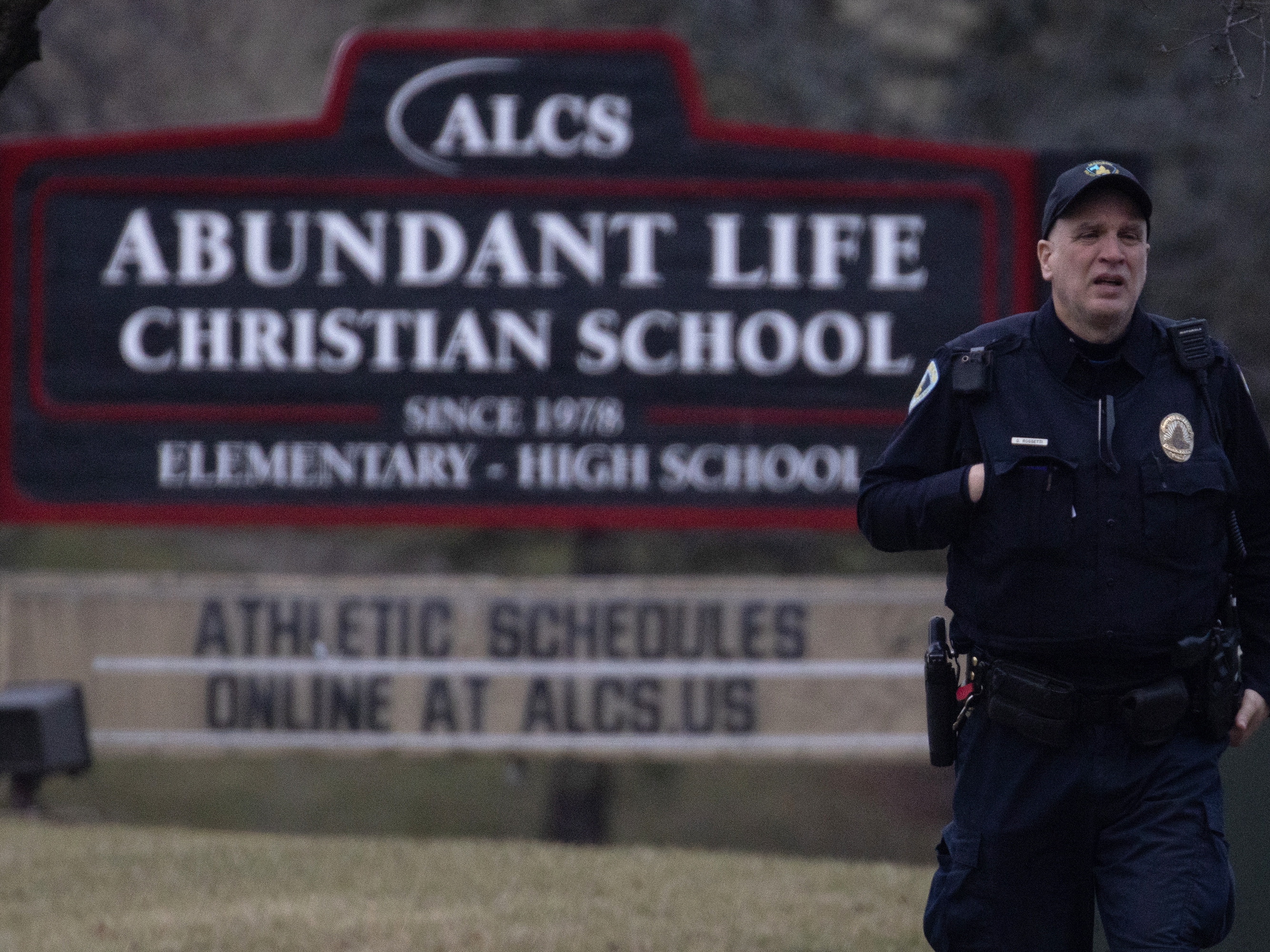 caption: A police officer stands guard in front of Abundant Life Christian School on Monday in Madison, Wis.