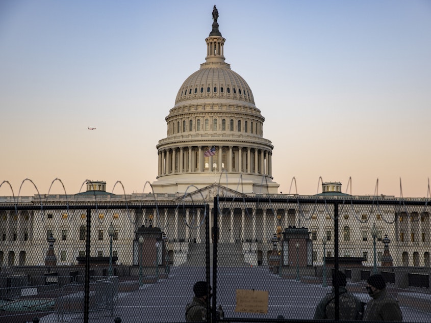 caption: The U.S. Capitol is seen Monday, the day before Donald Trump's second Senate impeachment trial is set to begin, as National Guard troops and Capitol Police stand guard.