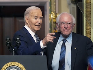 caption: President Biden stands with Sen. Bernie Sanders, I-Vt., on April 3, 2024. Four years ago, Sanders endorsed Biden, and the former rivals worked together to craft policy proposals that bridged Democratic divides.