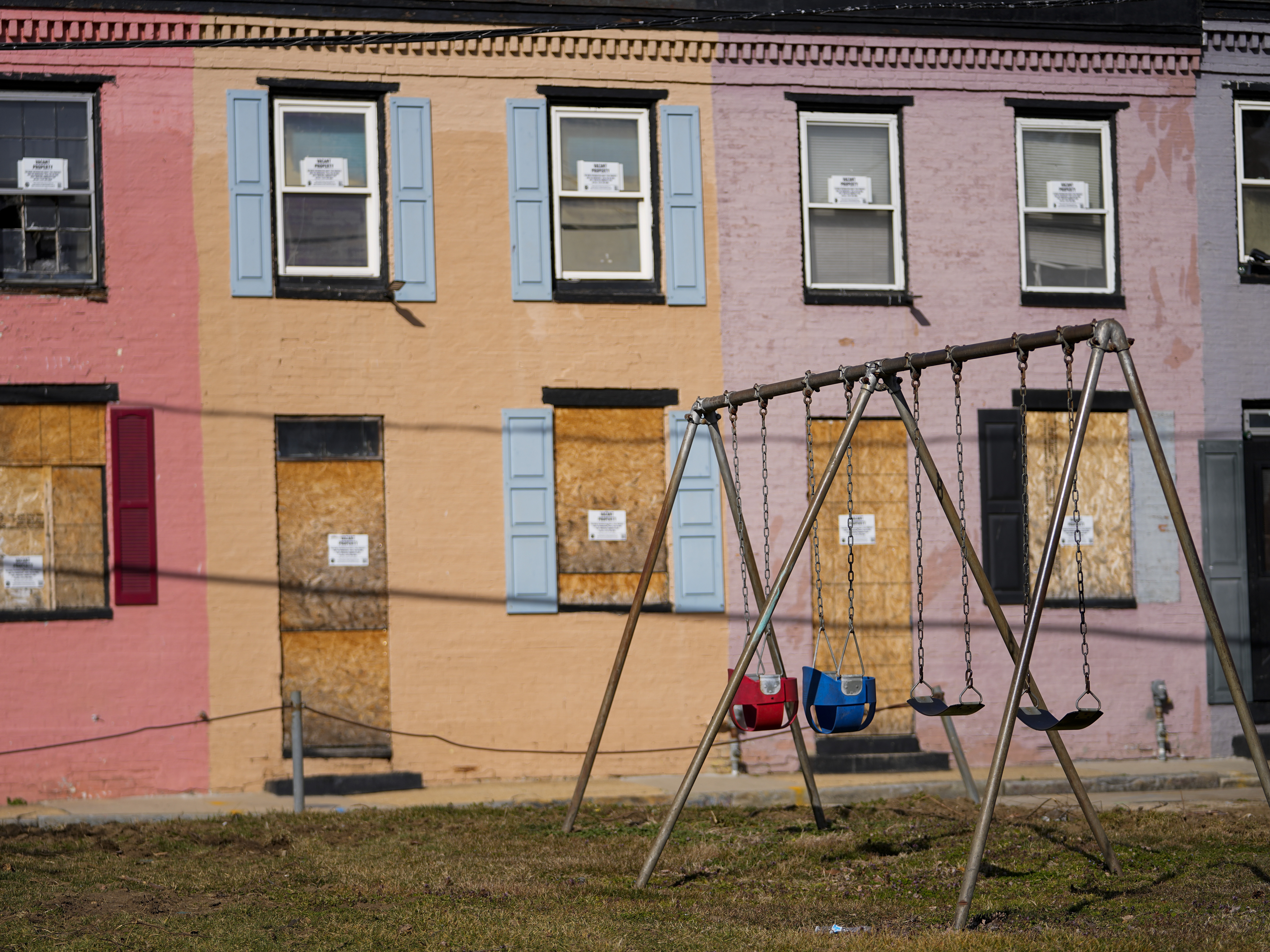 caption: Boarded doors and windows on Feb. 15, 2023, in Baltimore, where Black residents have alleged that redevelopment policies perpetuate racial discrimination.