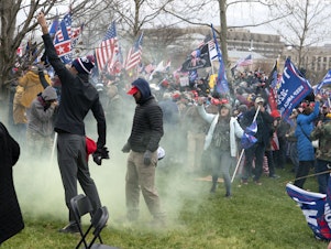 caption: Supporters of former President Donald Trump protest as U.S. Capitol Police officers shoot tear gas during the assault on the Capitol Jan. 6.
