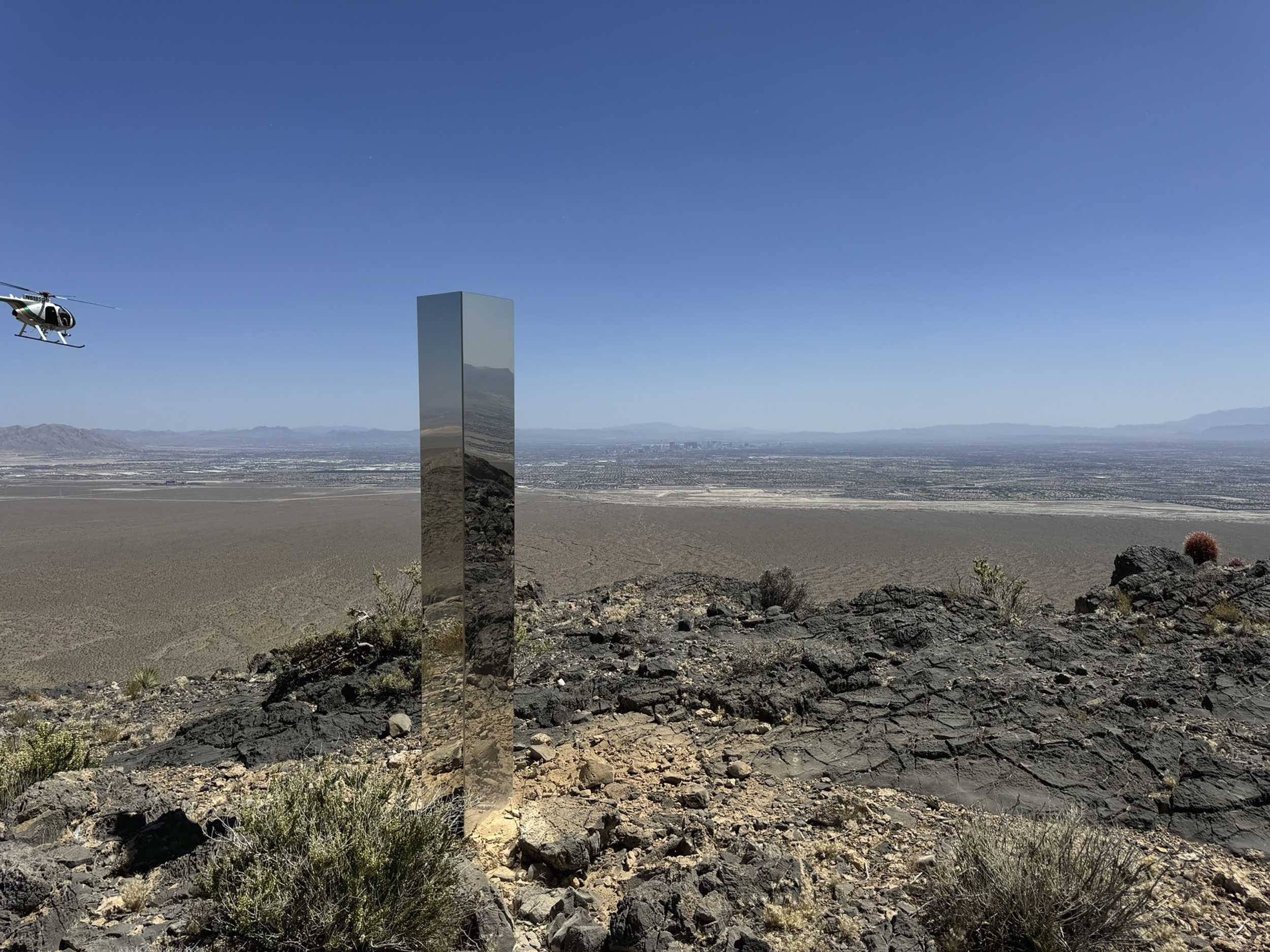 caption: This photo provided by the Las Vegas Metropolitan Police Department shows the monolith found in Gass Peak in Nevada's Desert National Wildlife Refuge.