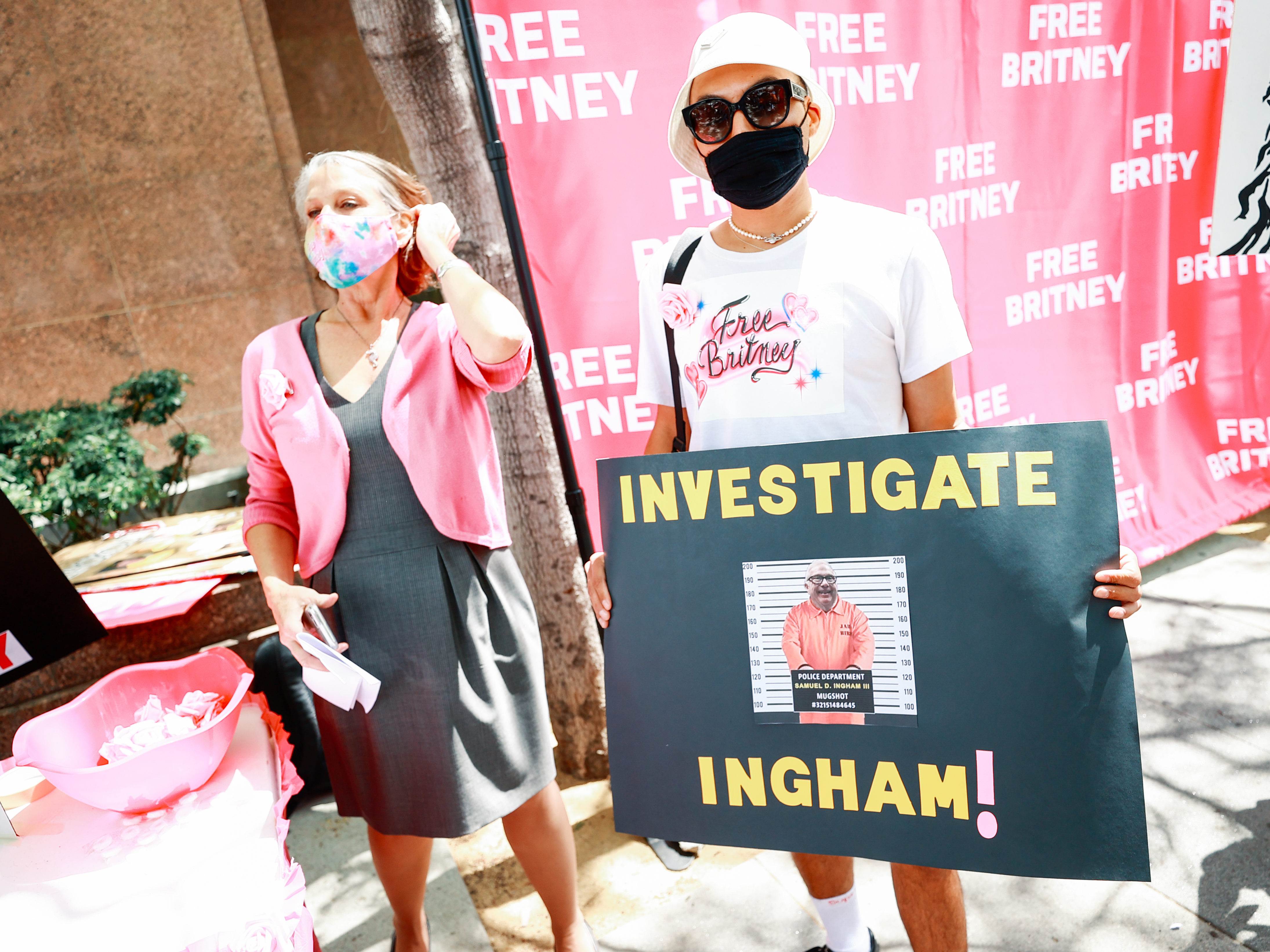 caption: #FreeBritney activists protesting outside a Los Angeles courthouse, sporting a sign that reads "Investigate Ingham!"