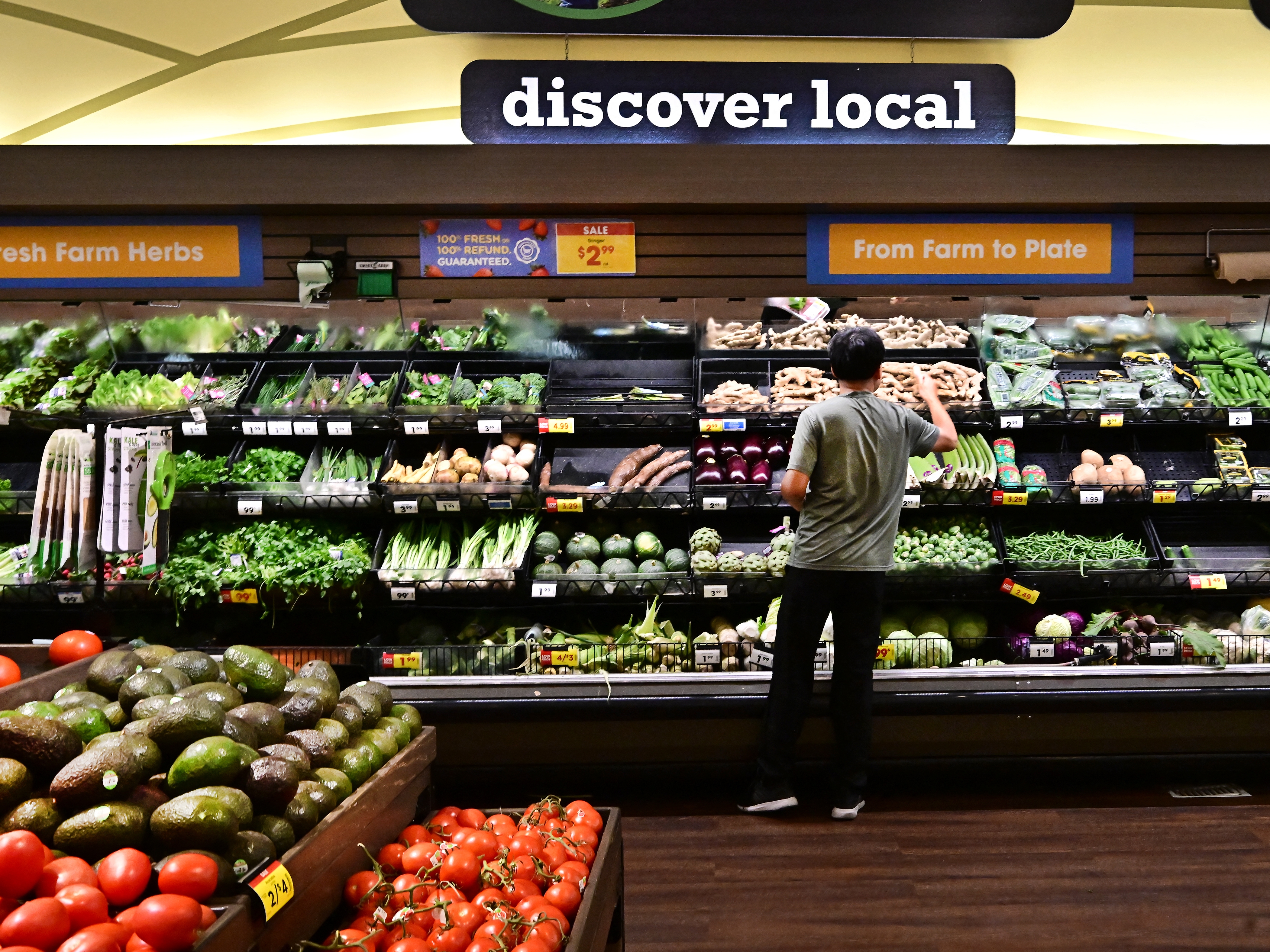 caption: A man shops for produce at a supermarket in Monterey Park, Calif.