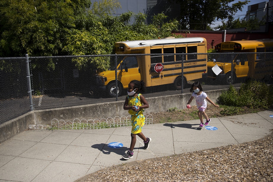 caption: Students play a game on the playground after collecting flowers on a walk with teacher Margarita Arias on Thursday, July 16, 2020, at the Denise Louie Education Center along Beacon Avenue South in Seattle. 