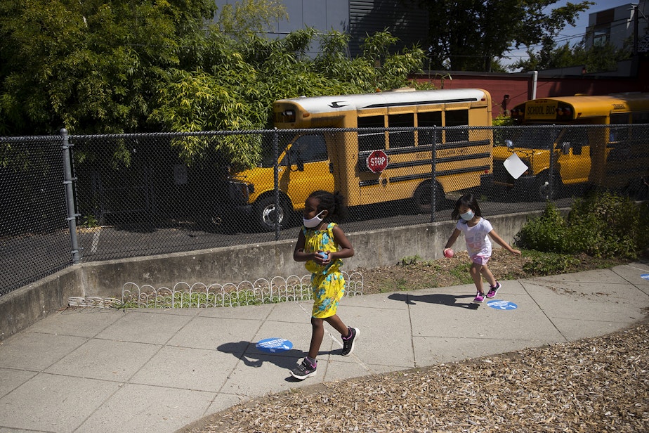 caption: Students play a game on the playground after collecting flowers on a walk with teacher Margarita Arias on Thursday, July 16, 2020, at the Denise Louie Education Center along Beacon Avenue South in Seattle.