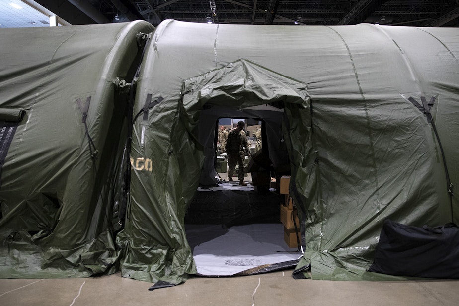 caption: U.S. Army soldiers are shown in the surgical area of a military field hospital set up by soldiers from the 627th Army Hospital from Fort Carson, Colorado, as well as from Joint Base Lewis-McChord on Tuesday, March 31, 2020, at the CenturyLink Field Event Center in Seattle.