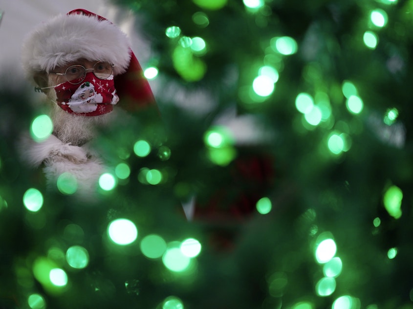 caption: Bill Sandeen, dressed as Santa Claus, waits for the opening of a Santa drive-through selfie station in Las Vegas on Dec. 10. The real Santa was vaccinated by Dr. Anthony Fauci at the North Pole.