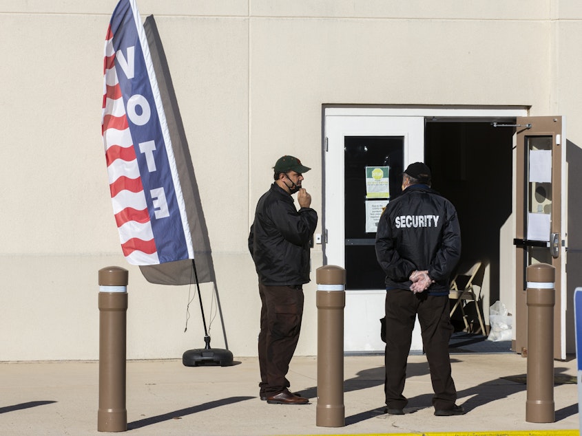 caption: Security personnel wait for voters outside the Leon County Supervisor of Elections office on Nov. 3, 2020, in Tallahassee, Fla.