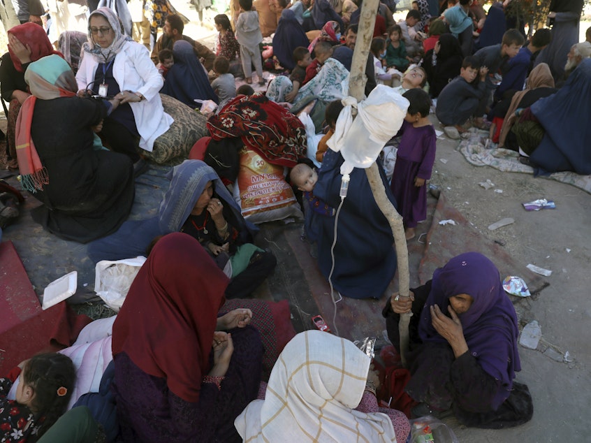 caption: Internally displaced Afghan women from northern provinces, who fled their home due to fighting between the Taliban and Afghan security personnel, receive medical care in a public park in Kabul last Tuesday.