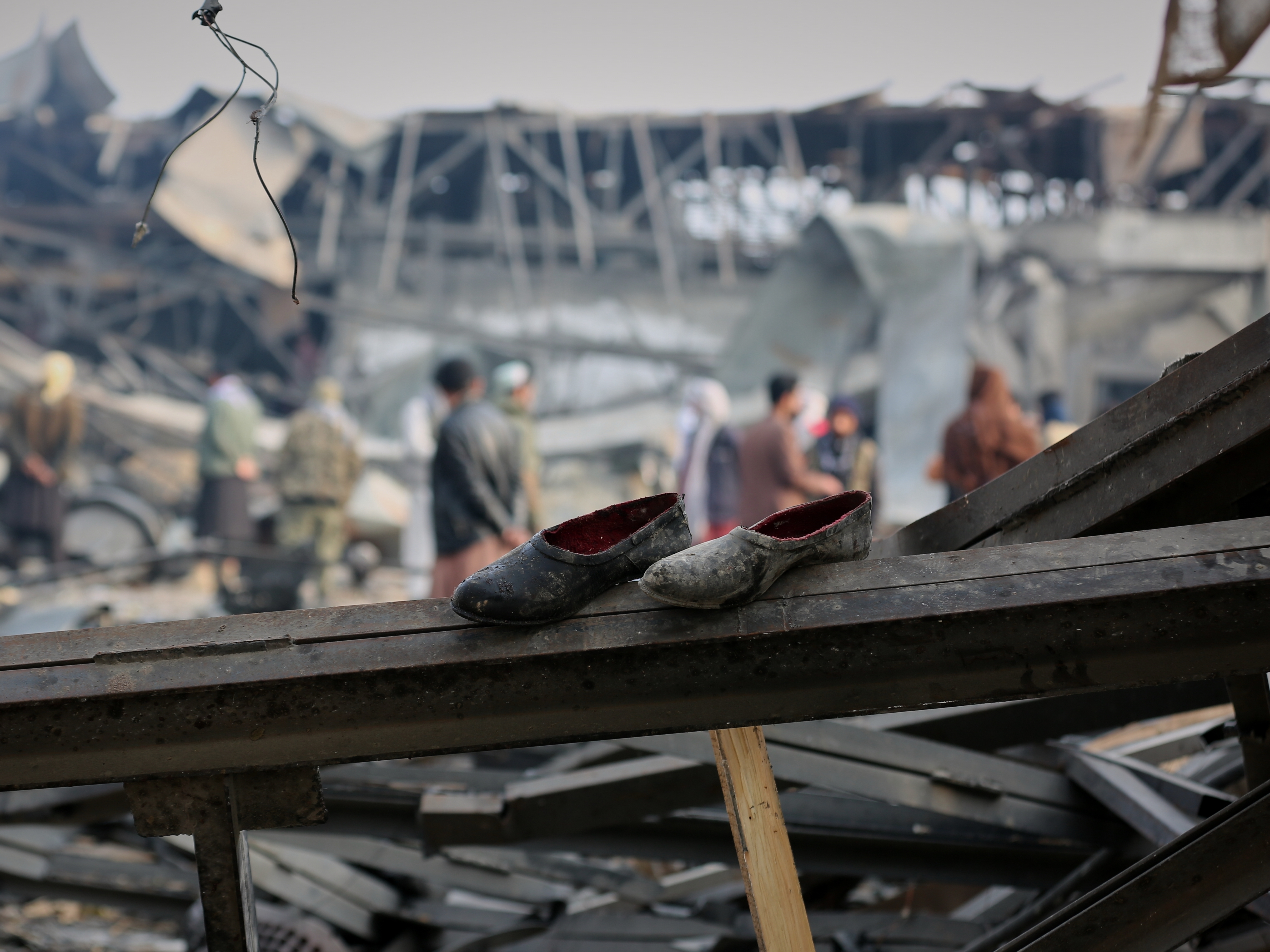 caption: FILE - Residents and rescue workers inspect the site of an airstrike at a drug rehabilitation hospital in Kabul, Afghanistan, March 17, 2026.