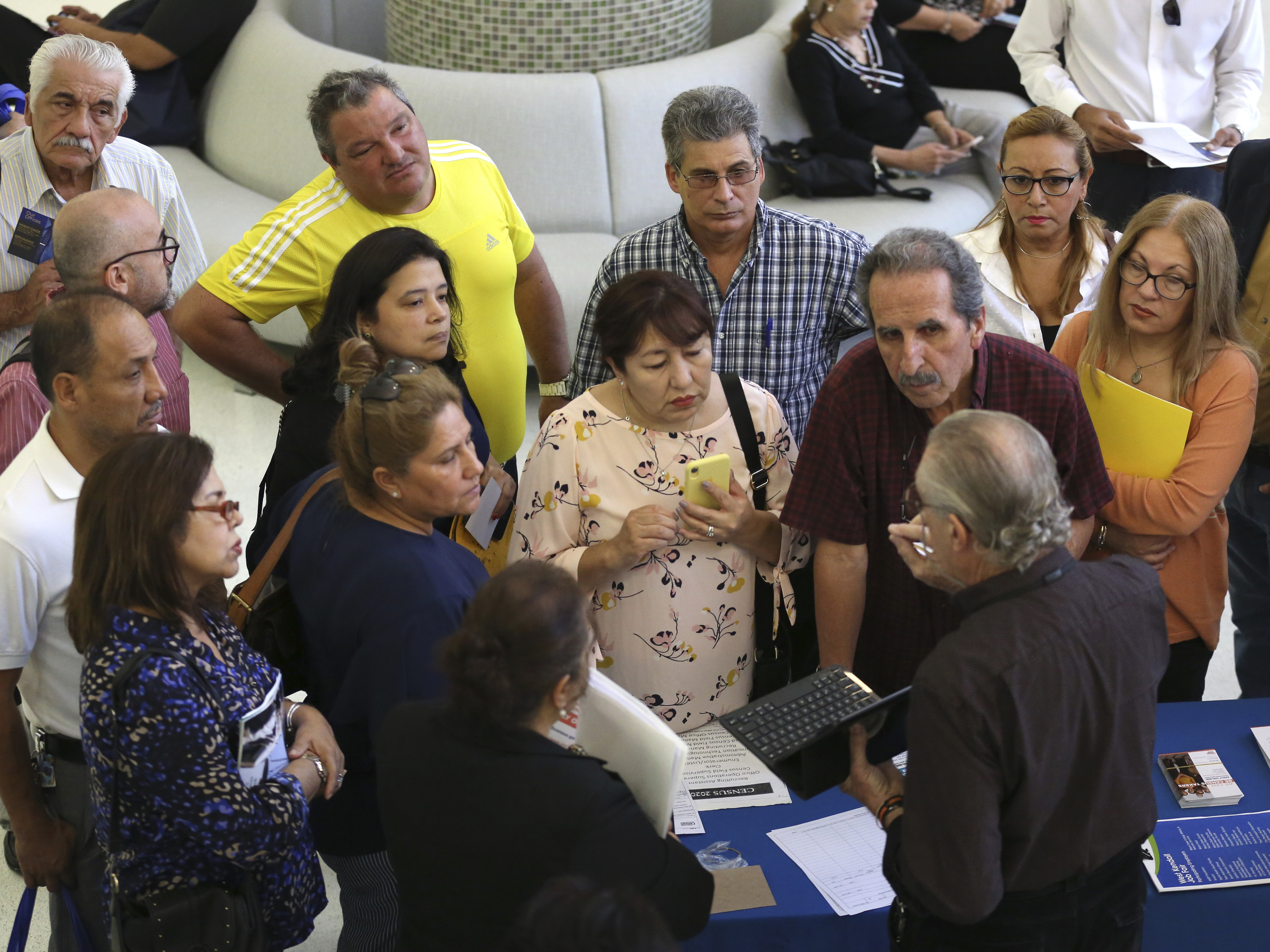 caption: People inquire about temporary positions available for the 2020 census during a job fair in Miami in September 2019.