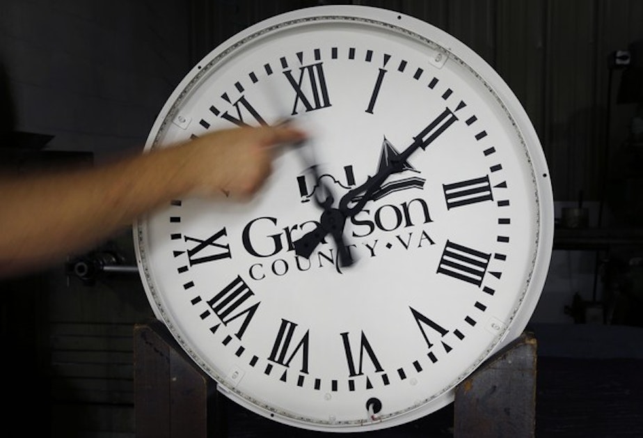 caption: <p>In this Thursday, Nov. 3, 2016 photo, a worker pulls the minute hand on a Grayson Virginia clock dial at Electric Time Co., in Medfield, Mass.</p>