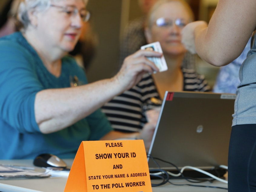 caption: A Utah poll worker checks a voter ID during the 2016 presidential election. Eleven states have strict voter ID laws, while 24 have less stringent laws for an ID to vote. Democrats have begun to lower their resistance to the issue.