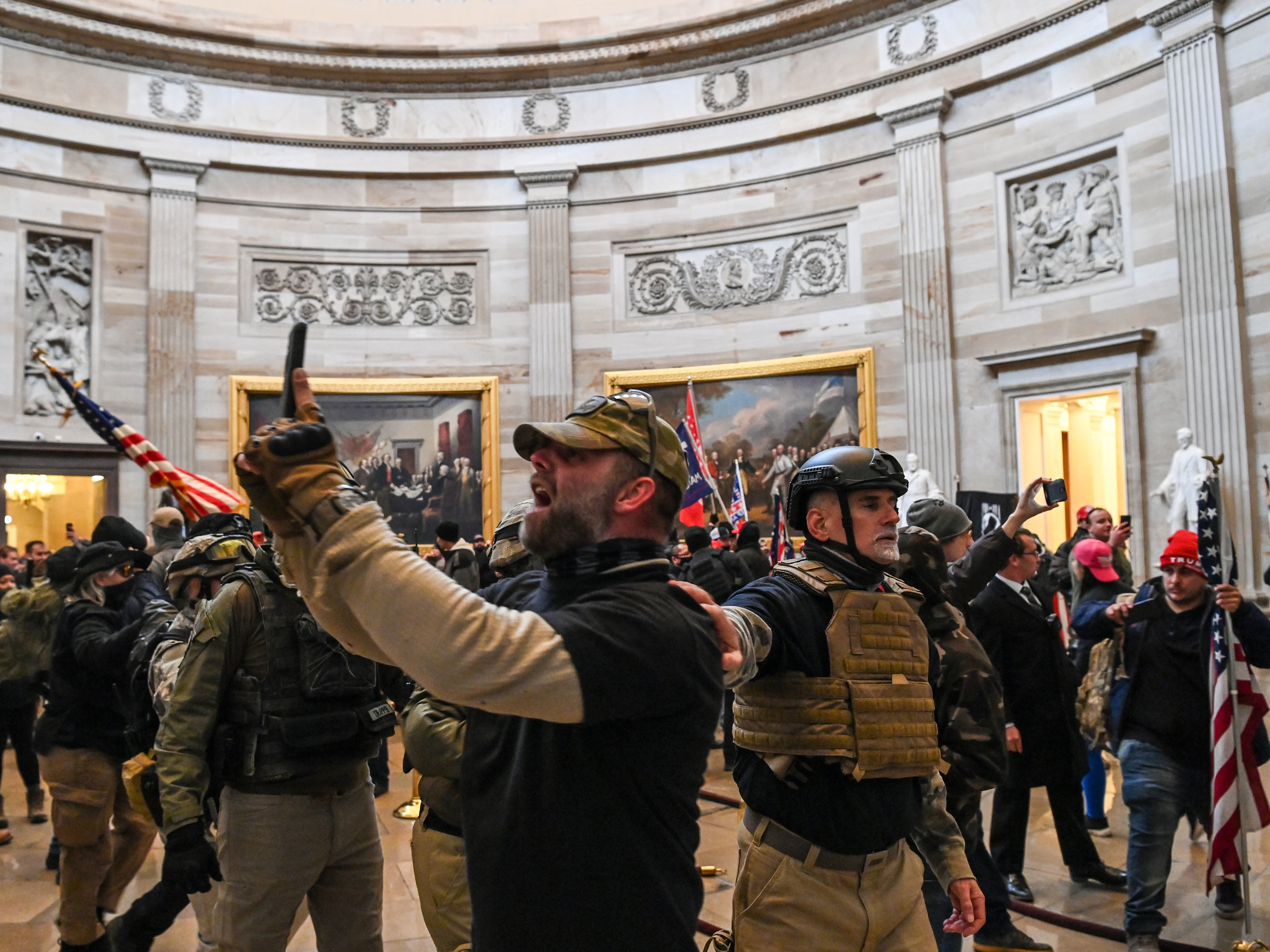 caption: Kenneth Harrelson, identified in an FBI affidavit as the man at center holding a phone in the Capitol Rotunda, is charged with obstructing an official proceeding, destruction of government property, entering a restricted building and conspiracy.