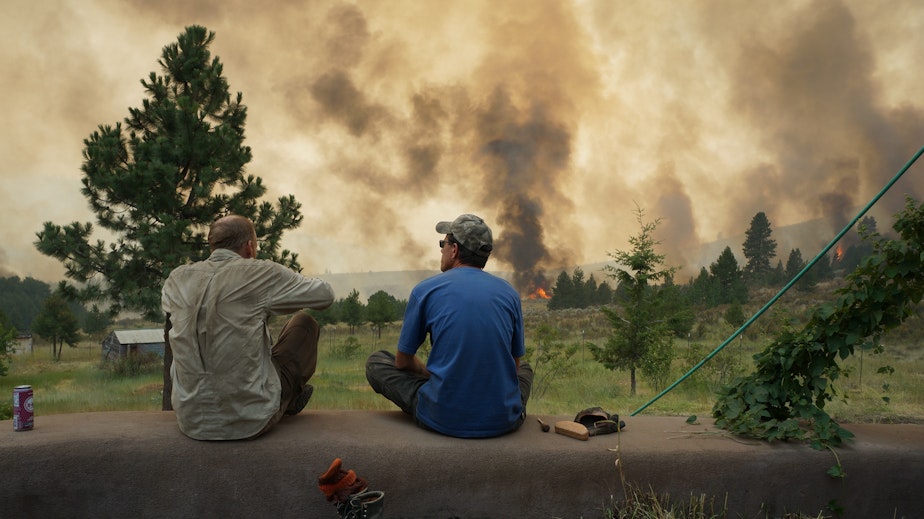 caption: Twig Wheeler (left) and his friend Edward Glidden look out over the Carlton Complex fire from Wheeler's home outside of Carlton, Washington. 