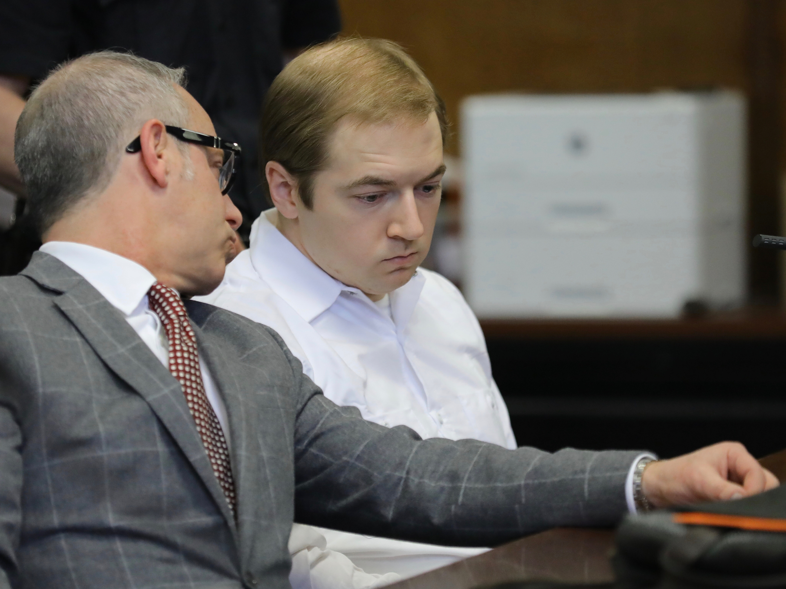 caption: James Jackson (right) confers with his lawyer during a hearing in criminal court Wednesday in New York. Jackson pleaded guilty to killing a black man with a sword, which prosecutors described as terrorism and a hate crime.