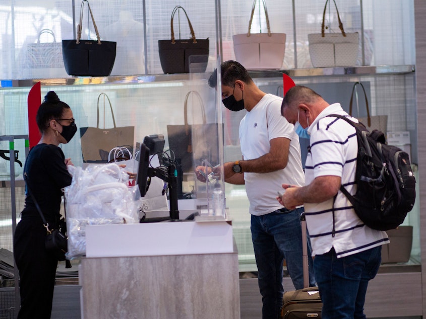 caption: People shop at Macy's in New York on Aug. 9, 2021.