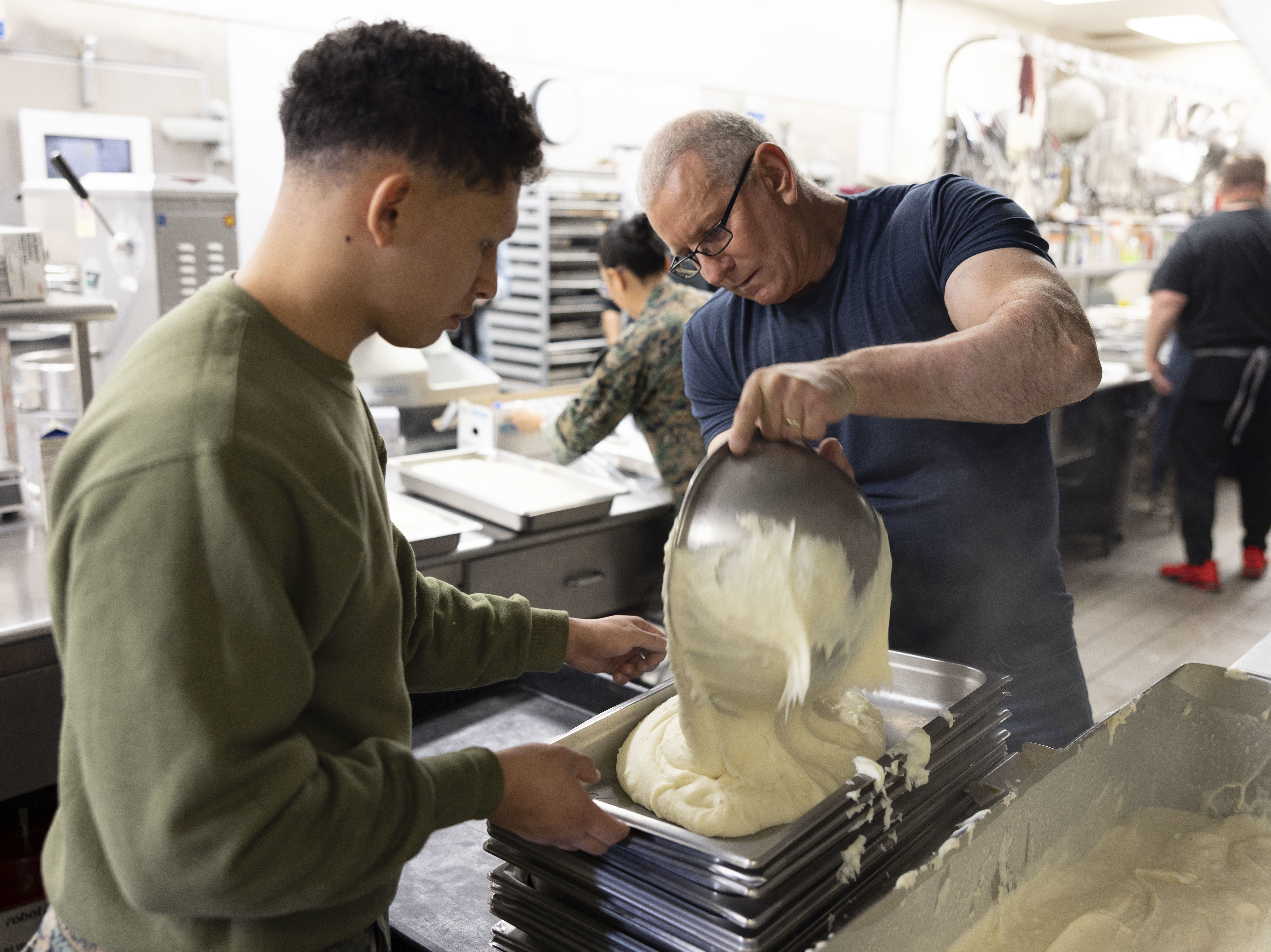caption: Chef Robert Irvine and Lance Cpl. Oscar Aguilar, with food services, 2nd Landing Support Battalion, prepare mashed potatoes for Friendsgiving dinner aboard Marine Corps Air Station Cherry Point, N.C., on Nov. 21, 2022.