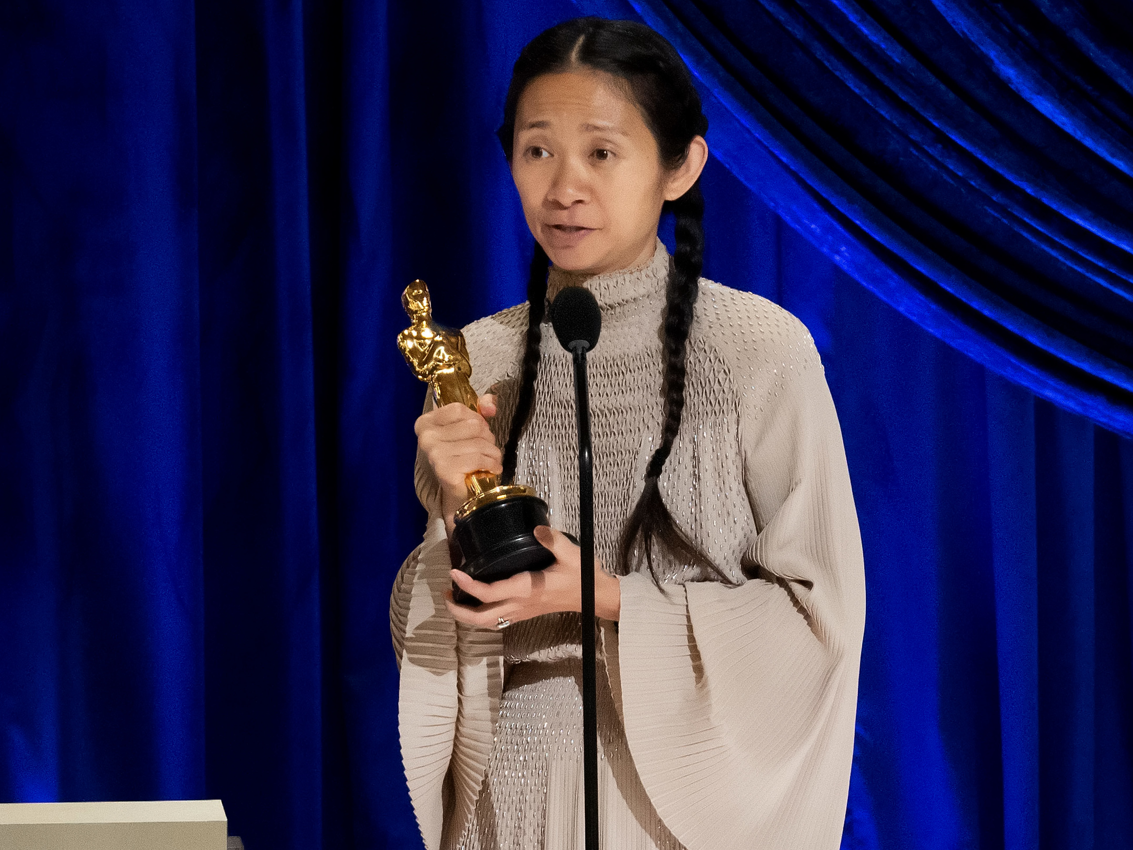 caption: Chloé Zhao accepts the Oscar for best director during Sunday night's ceremony. Her film <em>Nomadland </em>also won best picture.