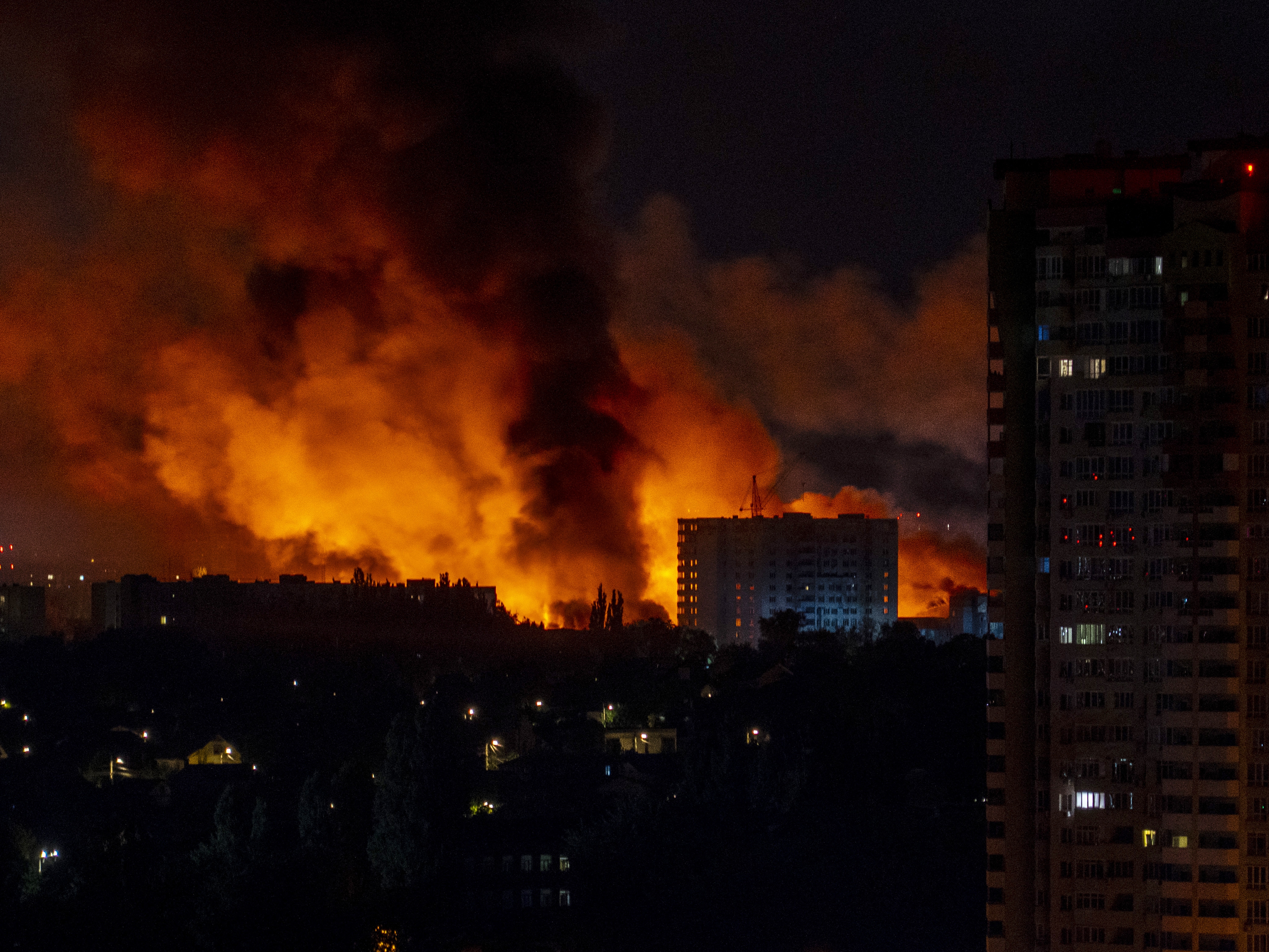 caption: Flames and smoke billow from buildings during mass Russian drones and missile strikes on Ukraine's capital in July 2025, amid the Russian invasion of Ukraine.