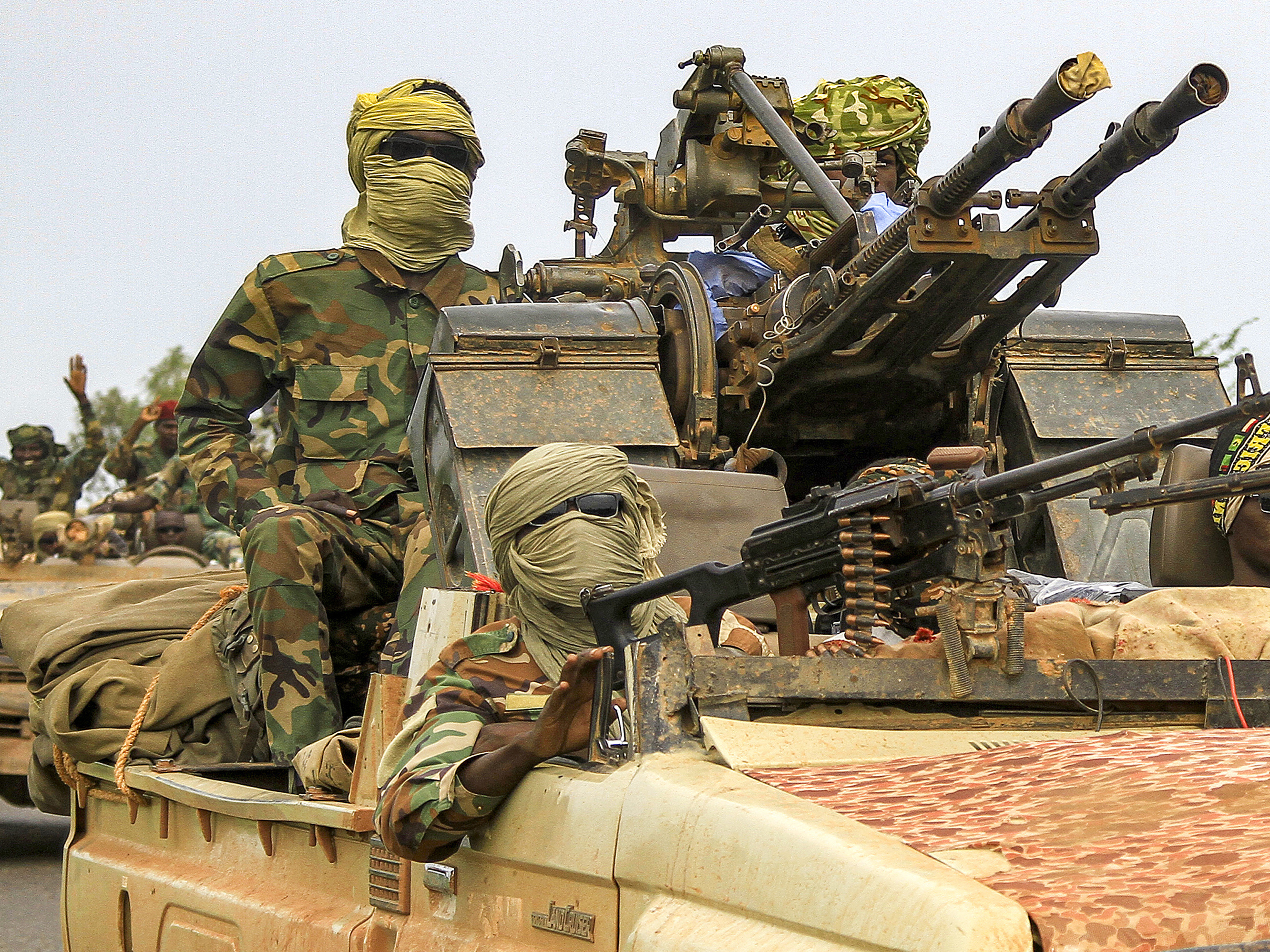 caption: Fighters ride in a vehicle moving in a military convoy accompanying the governor of Sudan's Darfur State on Aug. 30, 2023.
