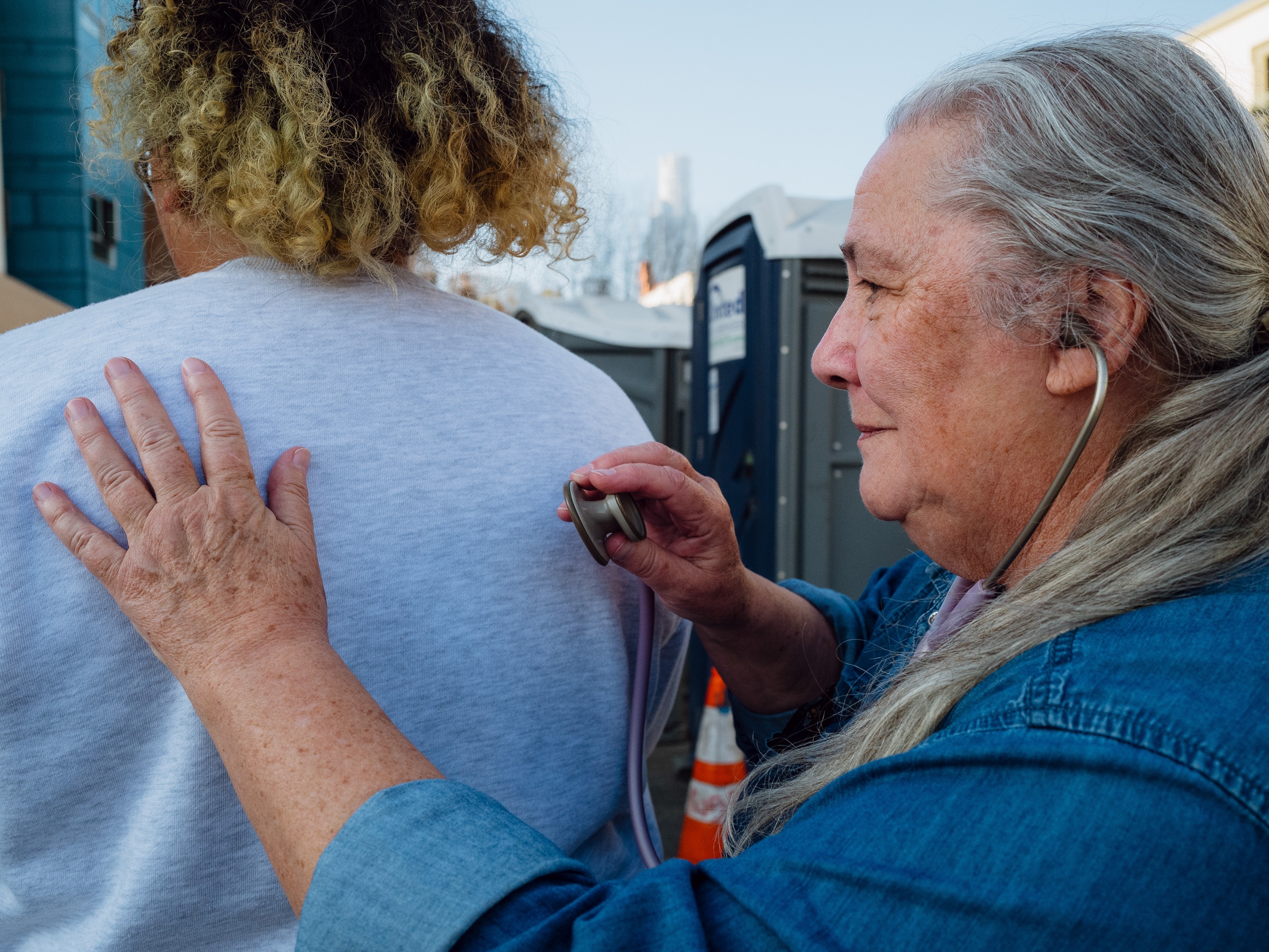 caption: Dr. Mary Marfisee conducts a brief breathing check on a woman on Los Angeles' Skid Row on December 15, 2025.