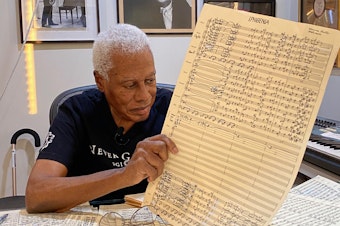 caption: Composer and saxophonist Wayne Shorter with a page from his <em>...(Iphigenia)</em> score.