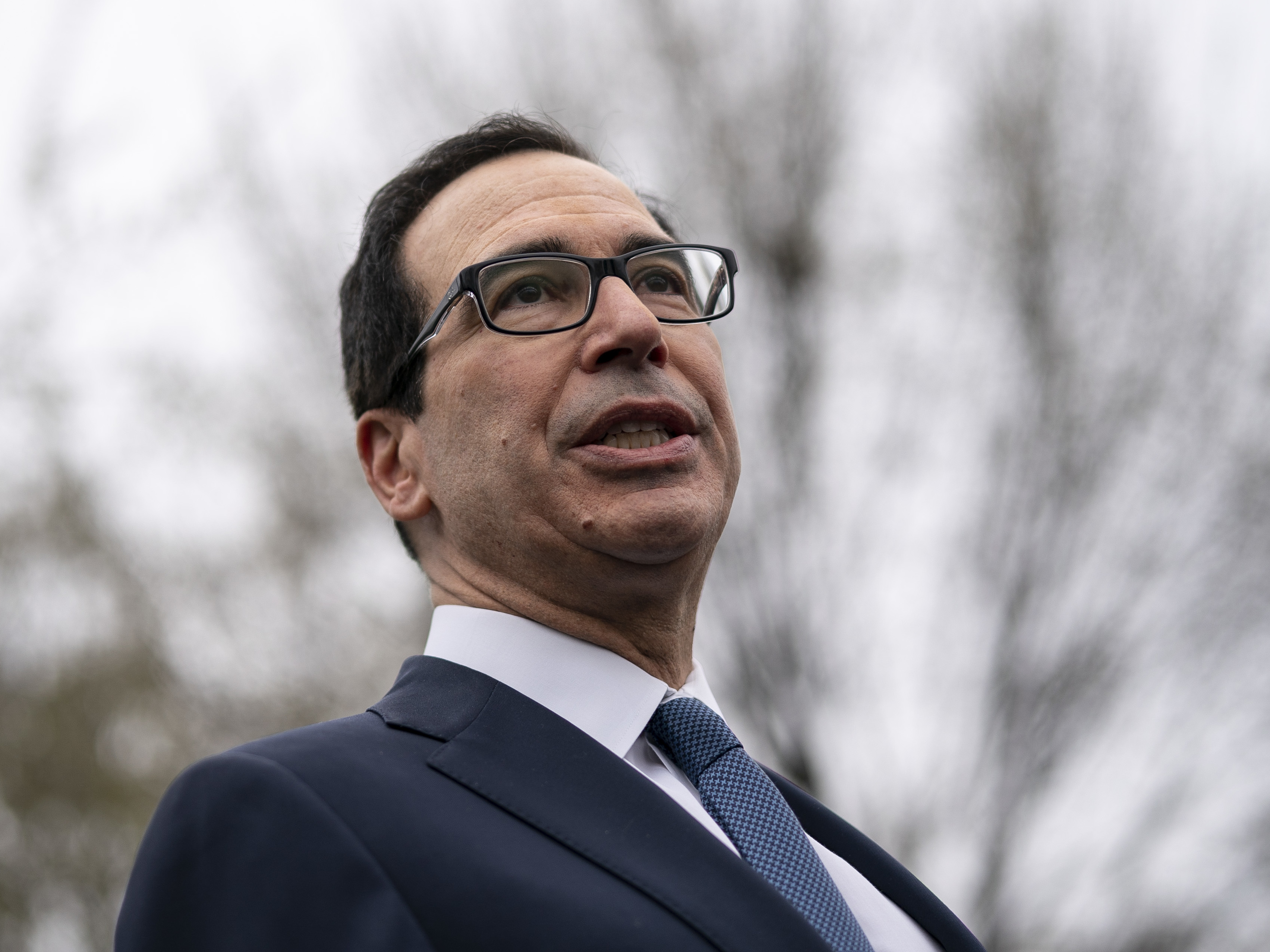 caption: U.S. Treasury Secretary Steven Mnuchin speaks to the press outside of the West Wing of the White House on Friday.