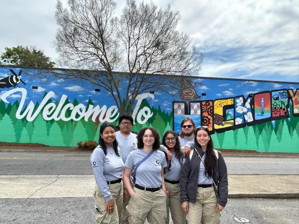 caption: Brandon Fernandez, second from left, with AmeriCorps colleagues in North Carolina this year, where they were helping with disaster recovery after Hurricane Helene. He and others struggled to hold back tears when their deployment was cut short.