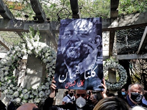 caption: Friends and family members of slain prominent Lebanese activist and intellectual Lokman Slim (shown in the raised image), attend a memorial ceremony in the garden of the family residence in the capital Beirut's southern suburbs, a week after he was found dead in his car, on Feb. 11. Slim, 58, was an outspoken critic of Hezbollah.