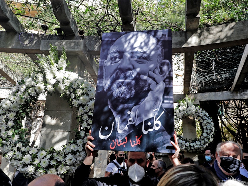 caption: Friends and family members of slain prominent Lebanese activist and intellectual Lokman Slim (shown in the raised image), attend a memorial ceremony in the garden of the family residence in the capital Beirut's southern suburbs, a week after he was found dead in his car, on Feb. 11. Slim, 58, was an outspoken critic of Hezbollah.