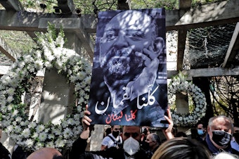 caption: Friends and family members of slain prominent Lebanese activist and intellectual Lokman Slim (shown in the raised image), attend a memorial ceremony in the garden of the family residence in the capital Beirut's southern suburbs, a week after he was found dead in his car, on Feb. 11. Slim, 58, was an outspoken critic of Hezbollah.