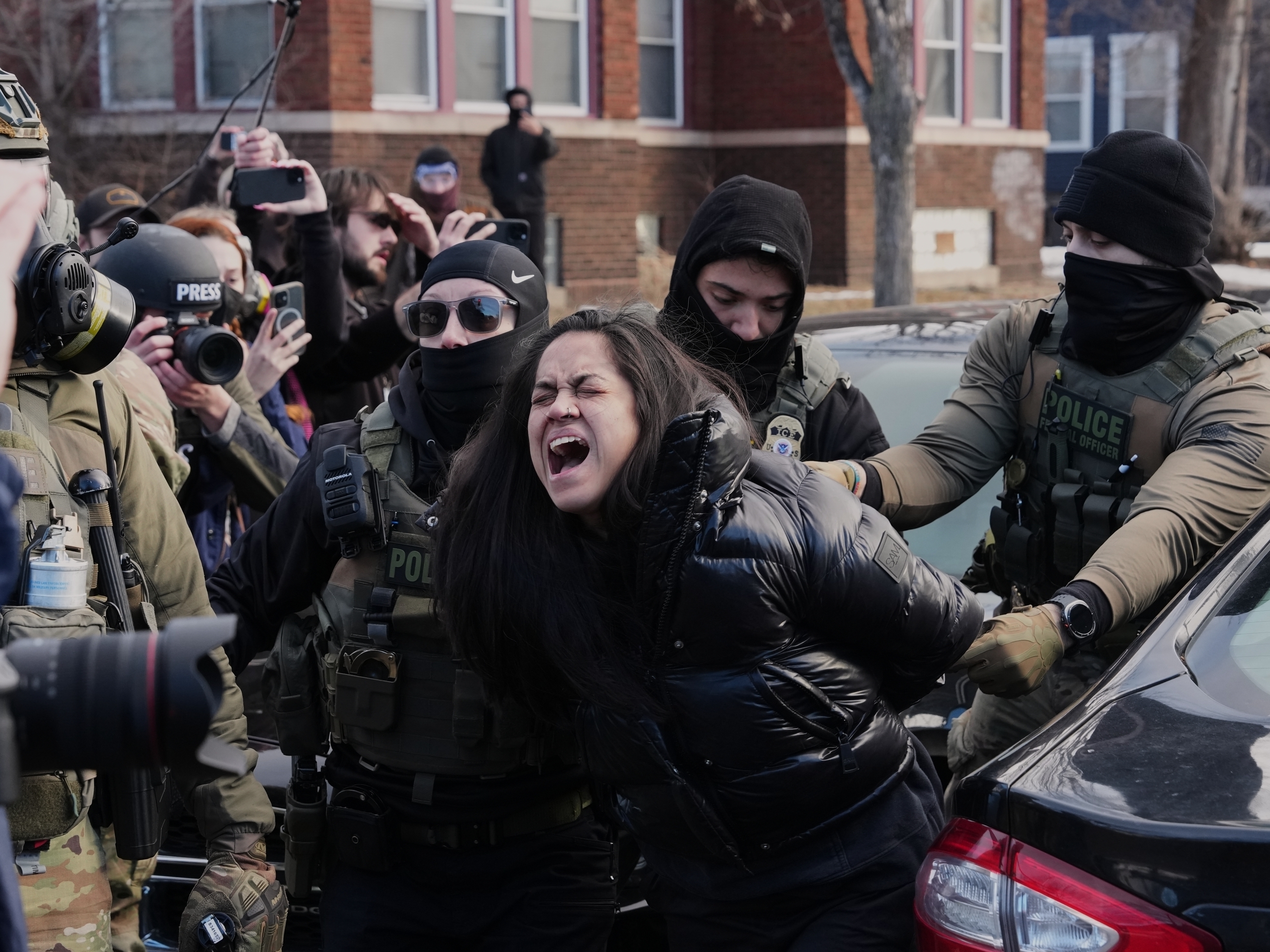 caption: Aliya Rahman is detained by federal agents near the scene where Renee Macklin Good was fatally shot by an ICE officer last week, Jan. 13, 2026, in Minneapolis.