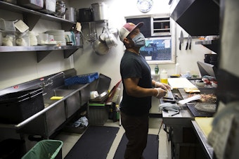 caption: Chef Celestino Nicolas works in the kitchen at the Tippe and Drague Alehouse on Friday, July 24, 2020, on Beacon Avenue South in Seattle.