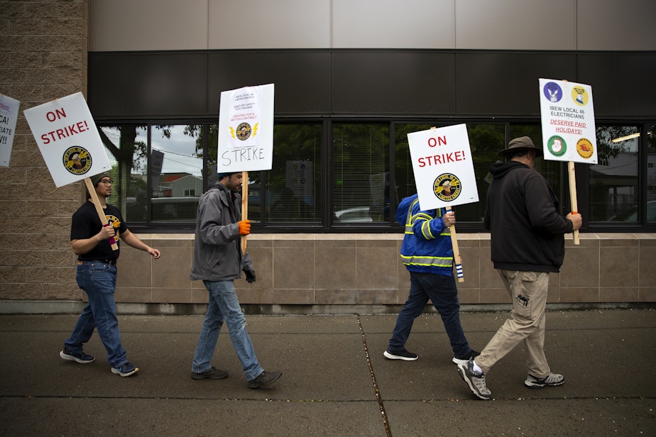 caption: IBEW Local 46 workers picket while on strike on Friday, April 26, 2024, along Stone Avenue North in Seattle. 
