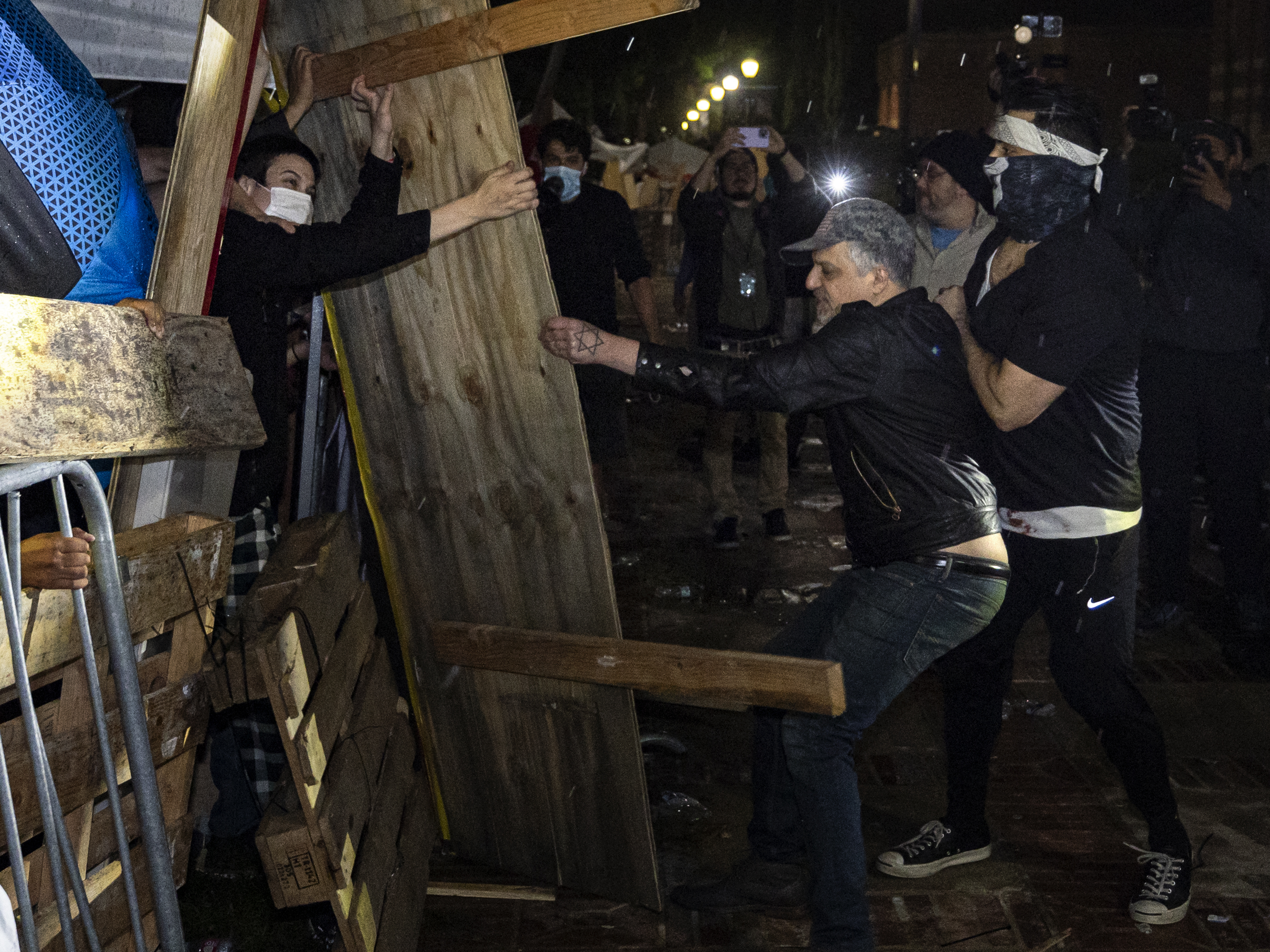 caption: Counterprotesters try to dismantle a pro-Palestinian encampment set up on the University of California, Los Angeles campus in the early hours of Wednesday.
