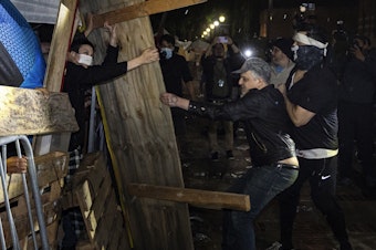 caption: Counterprotesters try to dismantle a pro-Palestinian encampment set up on the University of California, Los Angeles campus in the early hours of Wednesday.