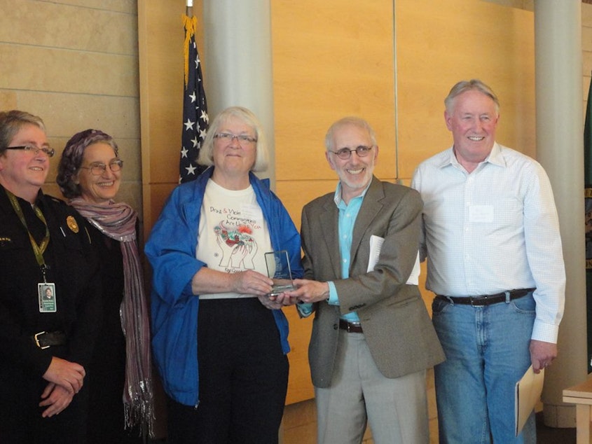 caption: Jean Darsie receives the Innovative Program Award from the Seattle Human Services Coalition in 2013 at Seattle City Hall from then-City-Councilmember Nick Licata. Bill Kirlin-Hackett is on the right, Laura Fox and Elizabeth Maupin on the left